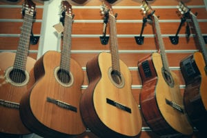 Row of classical acoustic guitars in musical store.